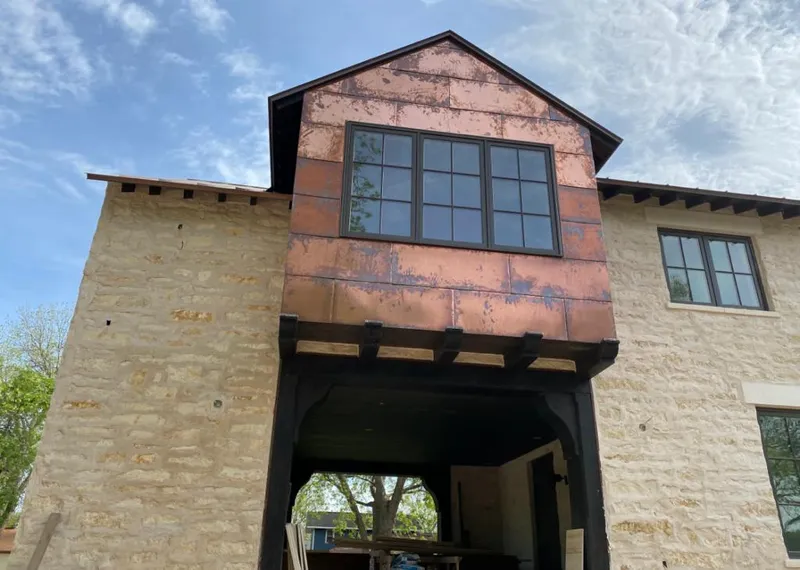 Copper metal panel facade on a stone building for Skylight Installation in Diboll